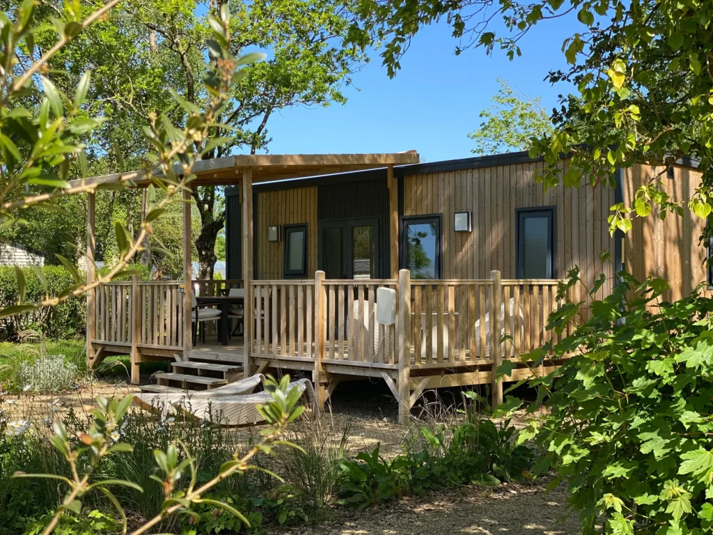 Cottage PREMIUM et sa terrasse en bois, entouré de végétation